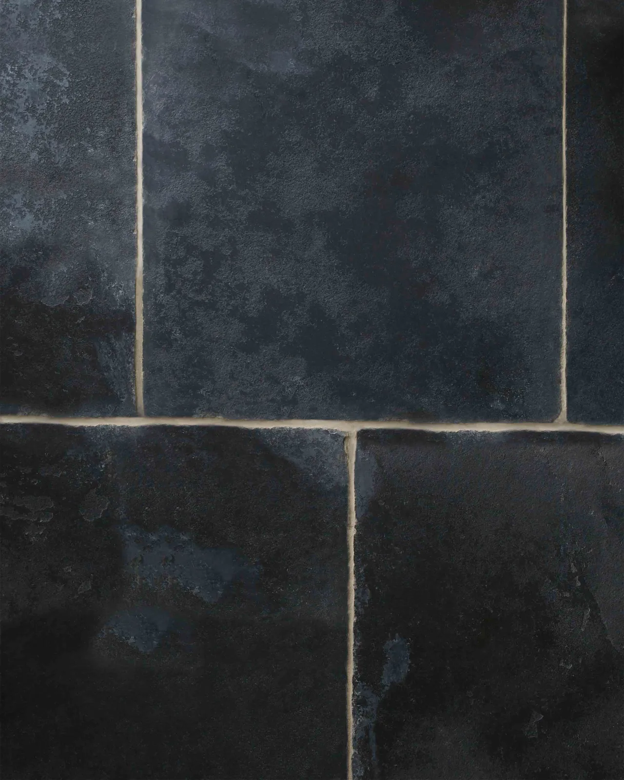 A close-up overhead view of Brushed Charcoal Limestone flooring, showing the subtle changes in texture and colour variation.