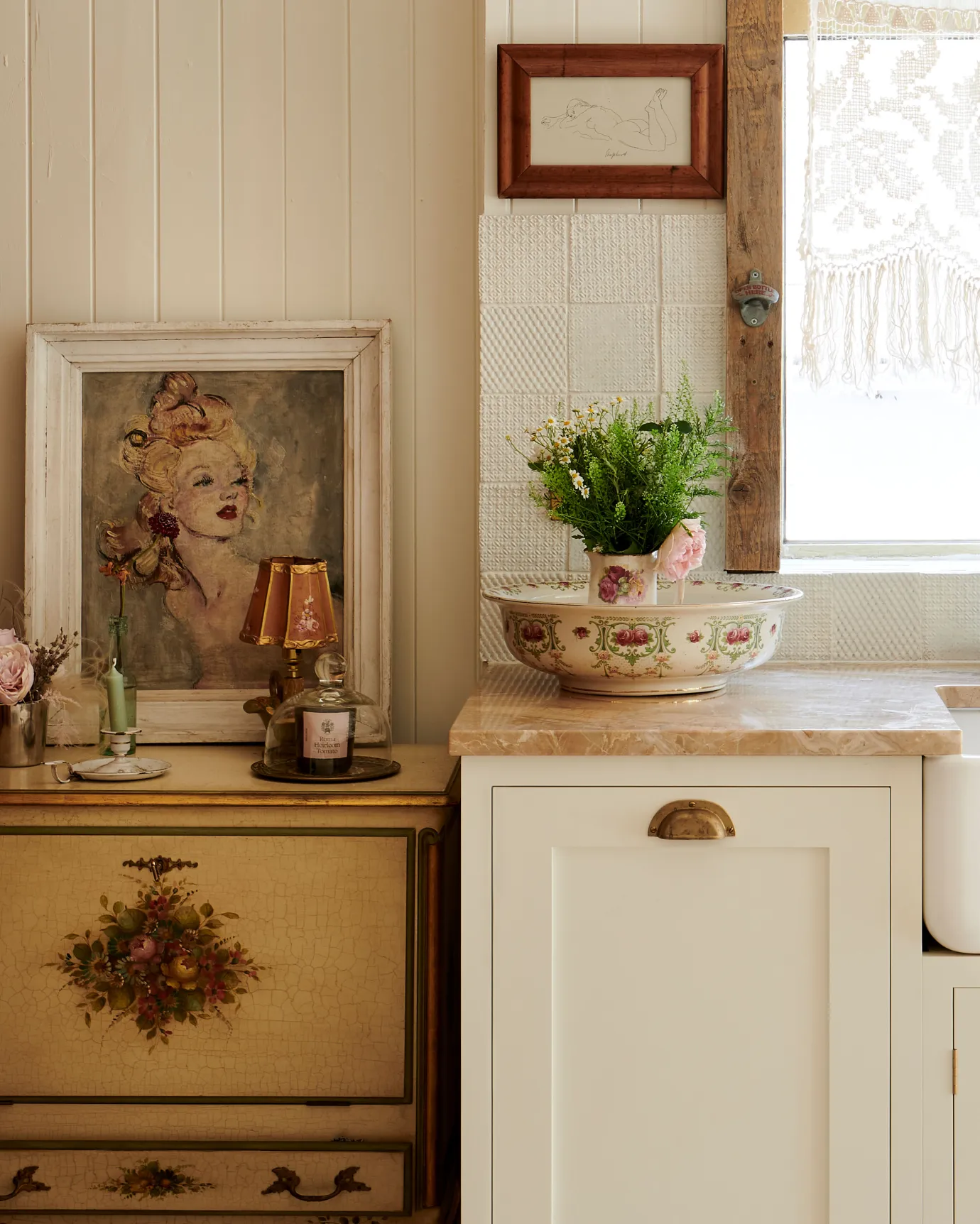A straight-on view of a bohemian Shaker-style kitchen with cream painted cupboards and a classic cup handle in an aged brass finish.