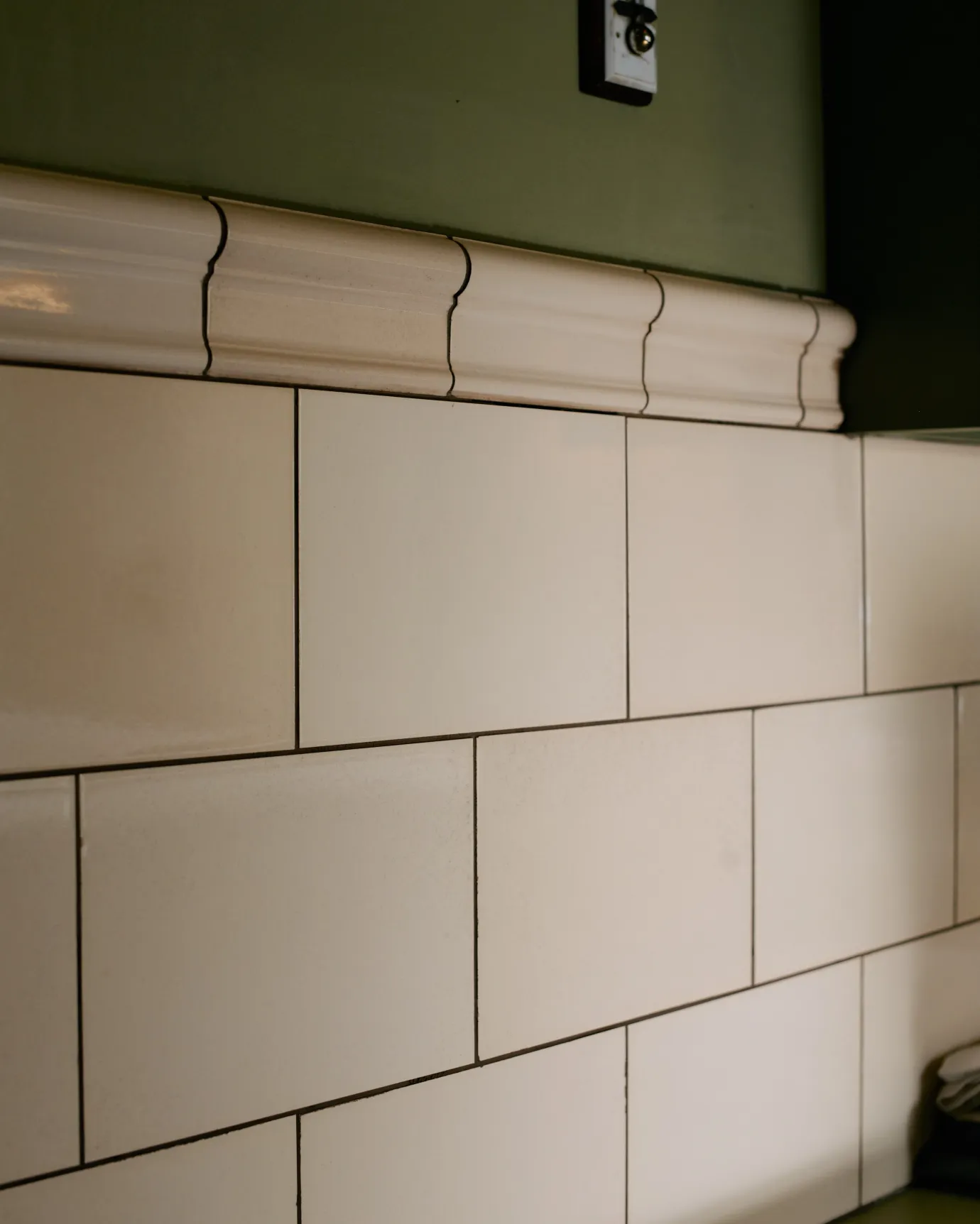 A close-up view of an elegant cream coloured border tile with a traditional beaded profile.