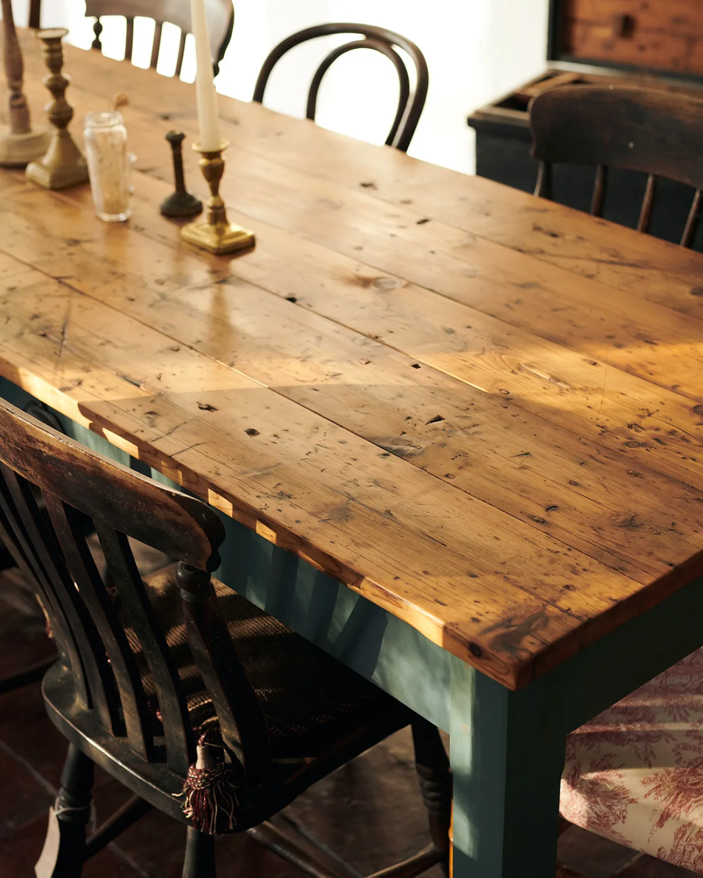 An oblique view of a rustic pine tabletop from a banquet-style dining table.